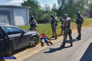 Policjanci CBŚP i zatrzymany mężczyzna oraz zabezpieczone przedmioty