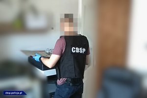 Policjanci CBŚP, dokumentacja, samochody i pieniądze