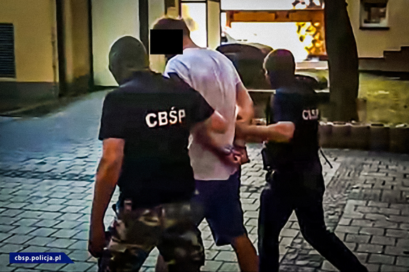 Policjanci CBŚP prowadzą zatrzymanego, a także pokazane przejęte przedmioty