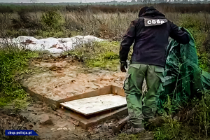 policjant CBŚP obok wejścia do plantacji