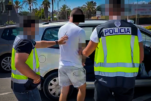 policjanci hiszpańscy prowadzą osobę zatrzymaną