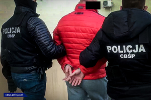 policjanci prowadzą zatrzymanego