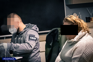 policjanci wypełniają dokumentację w obecności osoby zatrzymanej