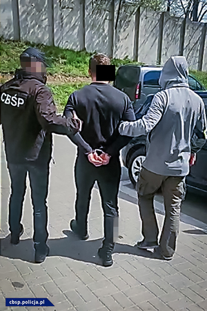 policjanci CBŚP prowadzą osobę zatrzymaną