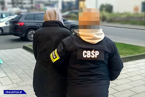 policjantka CBŚP prowadzi osobę zatrzymaną