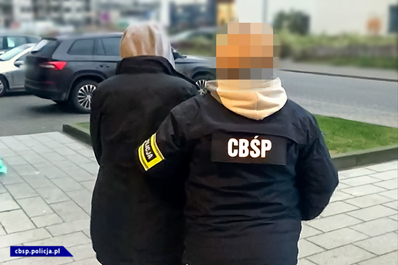 policjantka CBŚP prowadzi osobę zatrzymaną