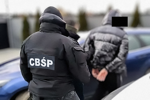 policjant cbśp prowadzi zatrzymanego