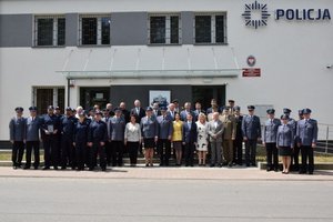 Uczestnicy uroczystości otwarcia nowego posterunku, zdjęcie grupowe przed budynkiem