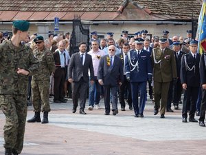 Kolorowa fotografia. Komendant Wojewódzki Policji w Rzeszowie wchodzi przez bramę leżajskiego sanktuarium w towarzystwie przedstawicieli innych służb mundurowych oraz starosty leżajskiego i wicemarszałka Sejmu.