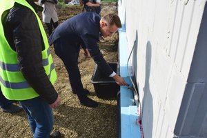 Policjanci i zaproszeni goście podczas uroczystości wmurowania aktu erekcyjnego na placu budowy nowego posterunku