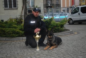 Na zdjęciu mł. asp. Bartłomiej Ciupak i Krak z pucharem za II miejsce w szkoleniu na dziedzińcu KMP w Rzeszowie.