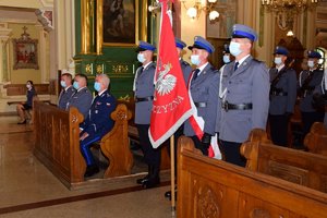 Zdjęcie wykonane w kościele. Poczet sztandarowy KWP na pierwszym planie - w tle, w ławkach siedzi Komendant Wojewódzki Policji w Rzeszowie wraz z zastępcami.