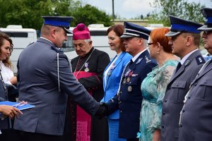 Policjant wręcza odznaczenie Komendantowi Wojewódzkiemu Policji w Rzeszowie insp. Dariuszowi Matusiakowi.