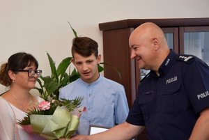 Komendant Powiatowy Policji w Ropczycach wręcza kwiaty podczas spotkania