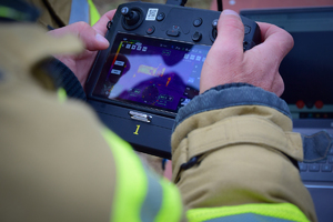 Zbliżenie na ekran panelu sterowania dronem. Na ekranie lokomotywa widoczna w podczerwieni