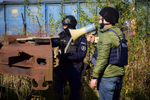 Policjanci podczas ćwiczeń - po lewej policjant oddziału prewencji, po prawej policyjny negocjator z megafonem