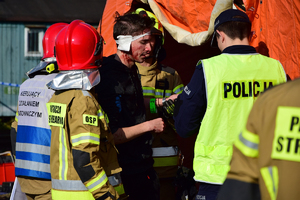 Policjanci i strażacy udzielają pomocy poszkodowanemu