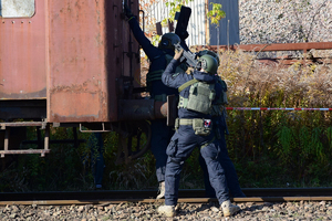 Policyjni antyterroryści podchodzą do wagonu. Pierwszy z lewej trzyma tarczę ochronną