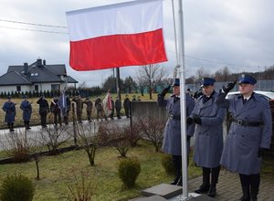 wciąganie flagi na maszt podczas odgrywania hymnu państwowego, na zdjęciu policjanci stojący przy maszcie