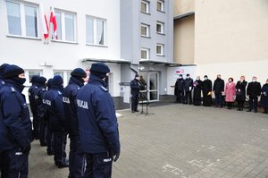 stojący w szyku przed budynkiem komisariatu policjanci oraz zaproszeni goście