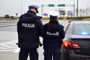 policjanci stojący na drodze i kontrolujący ruch kołowy