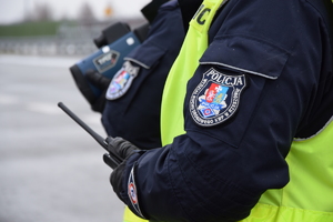 rękawy policjantów z ruchu drogowego, którzy trzymają w rekach stację oraz miernik prędkości