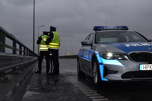 policjanci stojący na wiadukcie i kontrolujący ruch drogowy