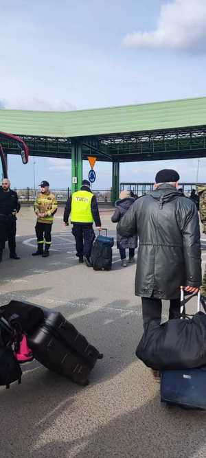 Przejście graniczne w Medyce, policjanci pomagają osobom wjeżdżającym do Polski