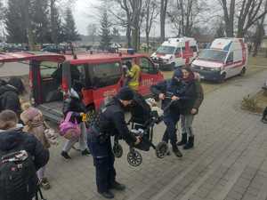 Policjanci przenoszący wózek z dzieckiem