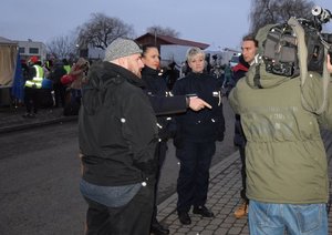 Policjanci i oficer łącznikowy na granicy - pomoc uchodzcom