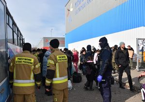 Policjant i strażacy przy autobusie