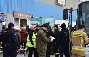 Policjanci, strażacy. wojsko niosący pomoc uchodźcom