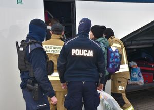 Policjanci i strażak przy autobusie