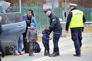 dwóch policjantów oraz mężczyzna z dwójką dzieci