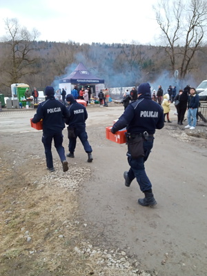 policjanc niosący paczki z żywnością