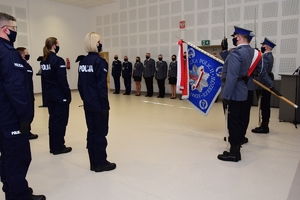 Po prawej, w centrum poczet sztandarowy, po lewej nowo przyjęci policjanci, w tle kadra kierownicza.