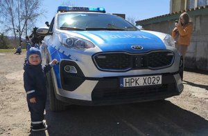 Policjanci spotkali się z dziećmi w Polańczyku. Na zdjęciach dziecko stojące przy radiowozie