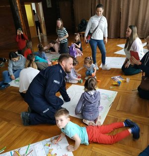 Policjanci biorący udział w spotkaniu wielkanocnym w Polańczyku z rodzinami Ukraińskimi. Na zdjęciach widoczni są policjanci, ksiądz oraz matki z dziecmi