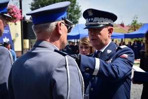 Komendant Główny Policji wręcza awanse i gratuluje odznaczonym policjantom.