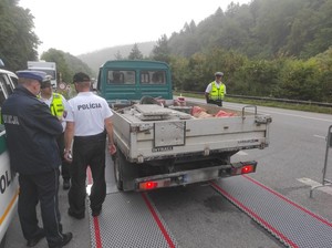 policjanci kontrolują przewożony ładunek przez kierującego miniciężarówką
