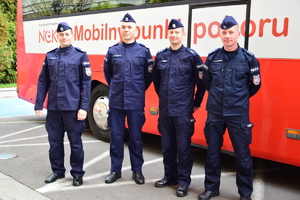 policjanci stojący przed autobusem, czterech policjantów