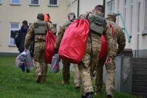 Policyjni antyterroryści z prezentami, w czapkach mikołajkowych zjeżdżają na linach z dachu budynku do szpitalnego okna