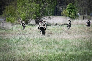 Policyjni antyterroryści i amerykańscy żołnierze podczas wspólnych ćwiczeń, na terenie zielonym.