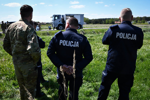 Policyjni antyterroryści i amerykańscy żołnierze podczas wspólnych ćwiczeń, na terenie zielonym.