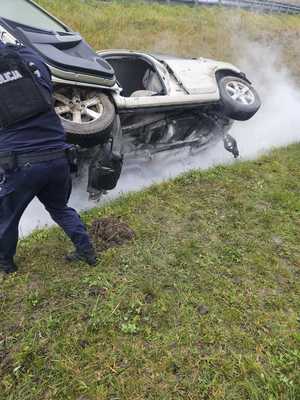 Miejsce zdarzenia drogowego i policjanci, którzy udzielali pomocy poszkodowanym