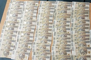 na fotografi widac rozlozone na stole pieniadze zabezpieczone w domu zatrzyamnego, sa to banknoty o nominale 200 zlotych