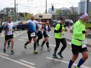 na zdjeciu wiadac biegnacych maratonczyków