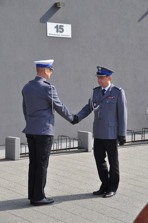 Komendant Wojewódzki Policji w Poznaniu insp. Piotr Mąka podaje rękę oficerowi Policji, który składał meldunek.