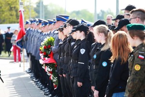 Dwuszereg policjantów i uczniów klas mundurowych z ostrością ustawioną na uczniów.