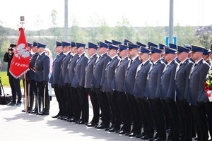 Dwuszereg policjantów i poczet sztandarowy Policji.